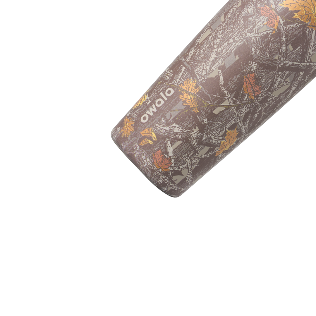 Owala SmoothSip Slider 20oz in Out of Sight, body close-up showing oak-leaf camouflage pattern in browns and greys with cream owala wordmark